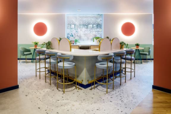 a dining room with a round table and chairs and a wall with three red spheres