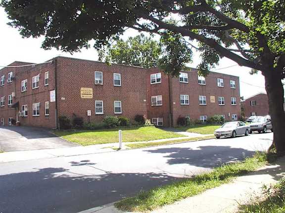A large brick building with a tree in front of it.