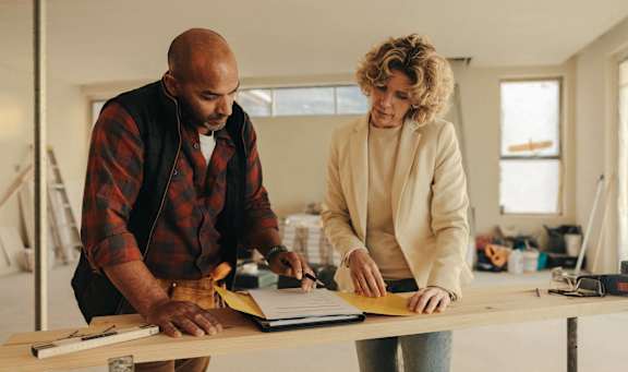 Two people are working together on a project in a workshop.