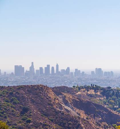 A city skyline is seen through a hazy atmosphere.