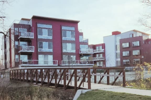 a wooden bridge in front of a row of colorful apartment buildings