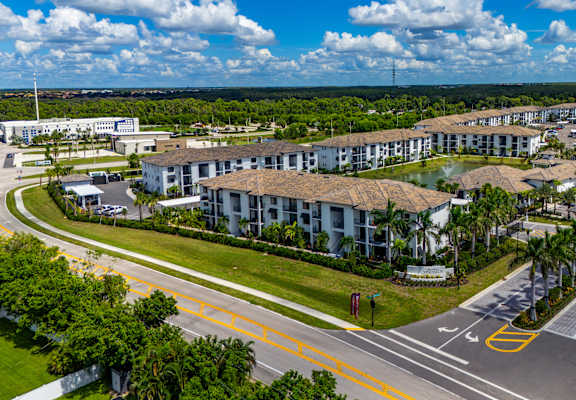 A large building complex with a parking lot in front.