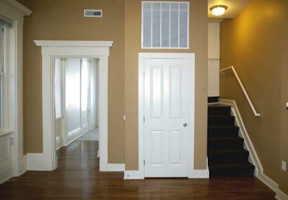 the entryway of a house with a white door and stairs