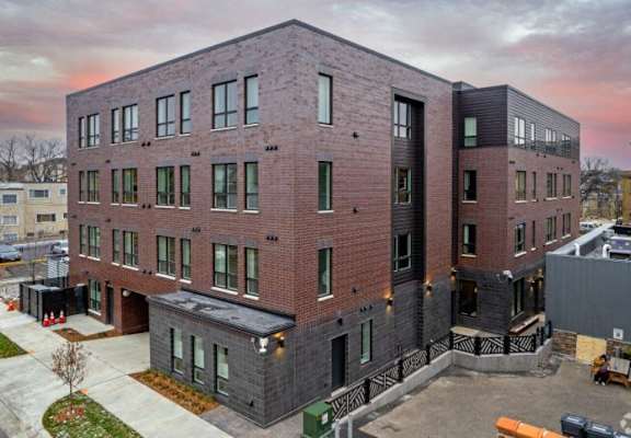 a brick apartment building with a sunset in the background