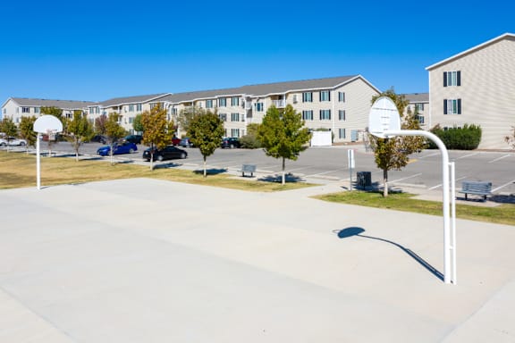 A basketball court in front of apartment buildings.