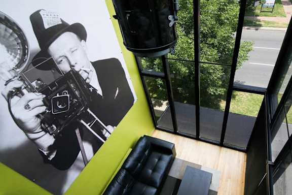 A black and white photo of a man with a camera is on the wall.