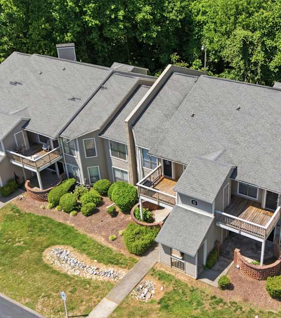 A large house with a grey roof and a driveway in front.