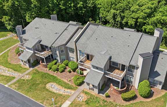 A large house with a grey roof and a driveway in front.
