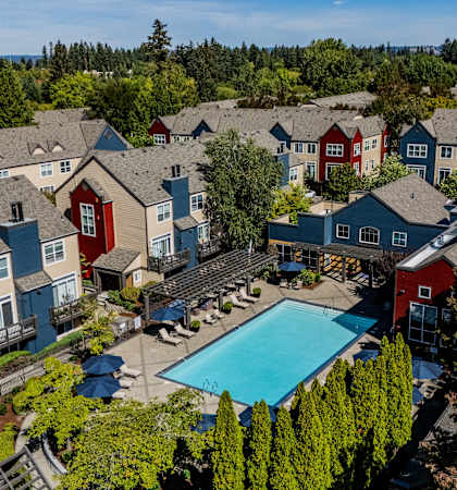 an aerial view of a resort style swimming pool surrounded by houses