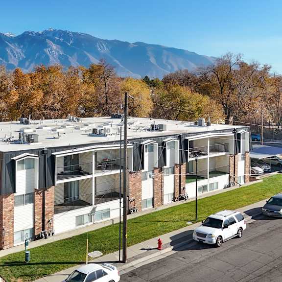 A modern building with a parking lot in front of it.