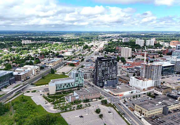 A cityscape with a large building in the center and a highway running through it.