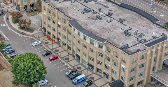 A parking lot in front of a large building.