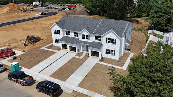 A house under construction with a grey roof and white walls.