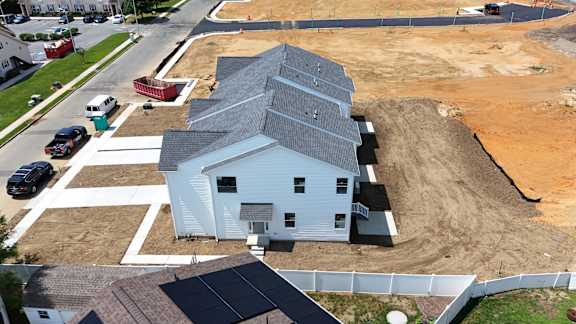 A house under construction with a blue roof and solar panels.