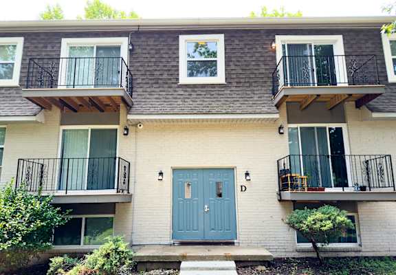 the front of a house with two balconies and a blue door