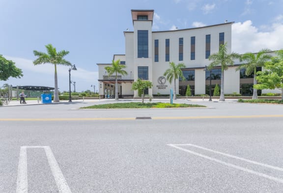 a large white building with palm trees in front of it