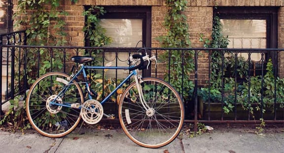 a blue bike is chained to a fence at The Enclave, Jersey City, New Jersey