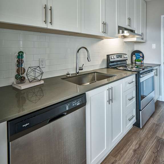 A modern kitchen with white cabinets and stainless steel appliances.