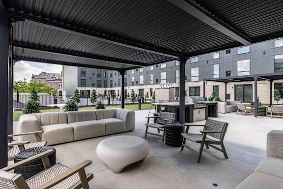 A patio with a white bean bag and wooden chairs.
