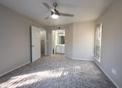 Thumbnail 1 of 5 - A room with a ceiling fan and carpeted floor.