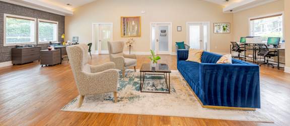 A living room with a blue couch and a rug.