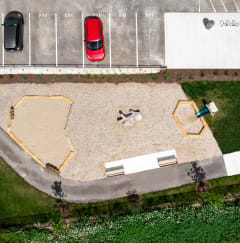 a drone shot of a parking lot with a bench and a bench in the middle of the