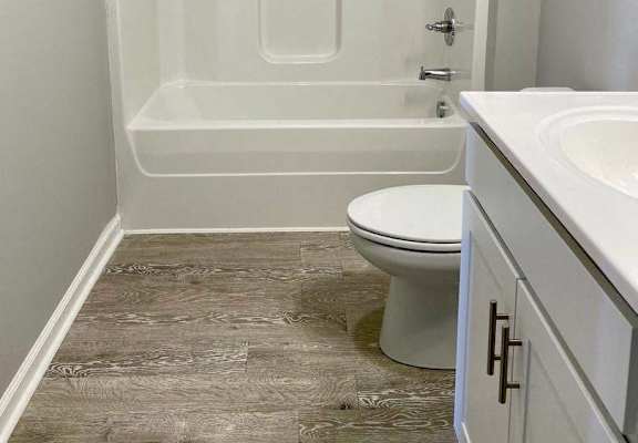 a bathroom with a toilet and a tub and a sink