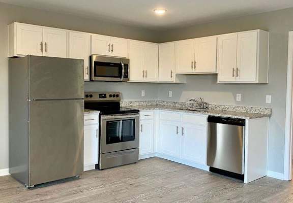 a kitchen with stainless steel appliances and white cabinets