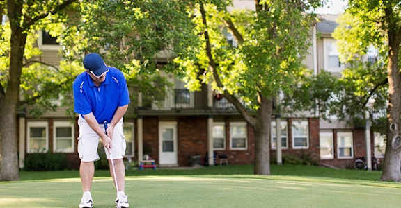 a man in a blue shirt is playing golf