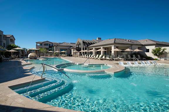 A large swimming pool with a slide and sun loungers.