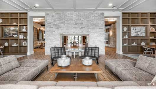 a living room with couches and a table and a fireplace at The Haven at Lake Britt Apartments, Winter Garden, FL 34787