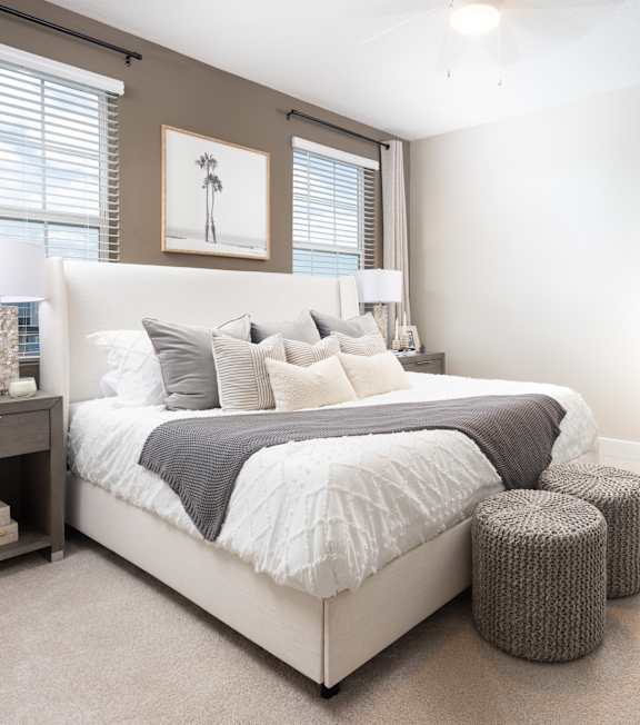 A bedroom with a large bed and a painting on the wall.