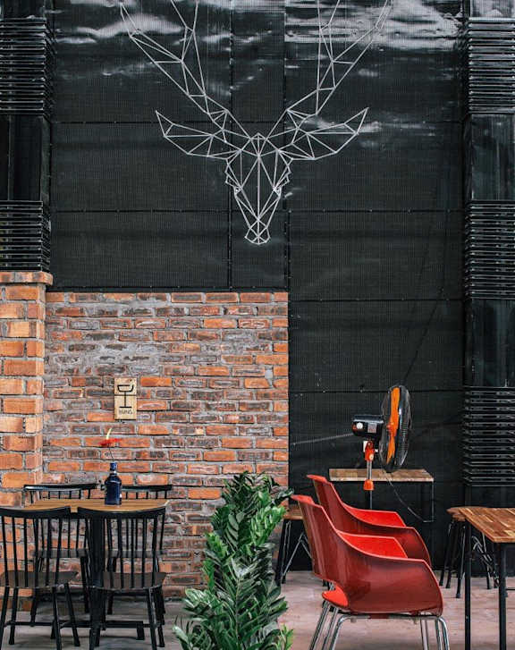 A room with a brick wall and a black wall with a white tree design on it.