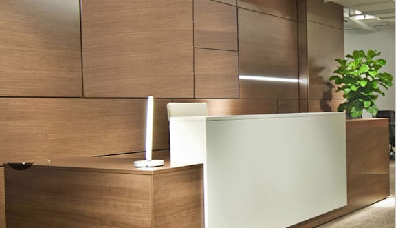 a reception desk in an office with a plant