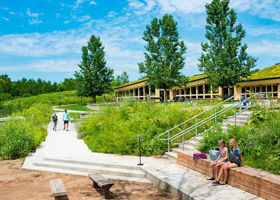A park with people walking and sitting on benches.