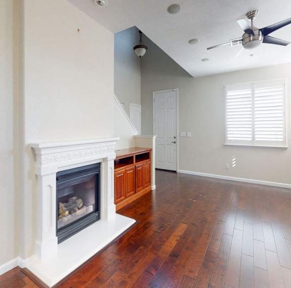A room with a fireplace and wood flooring.