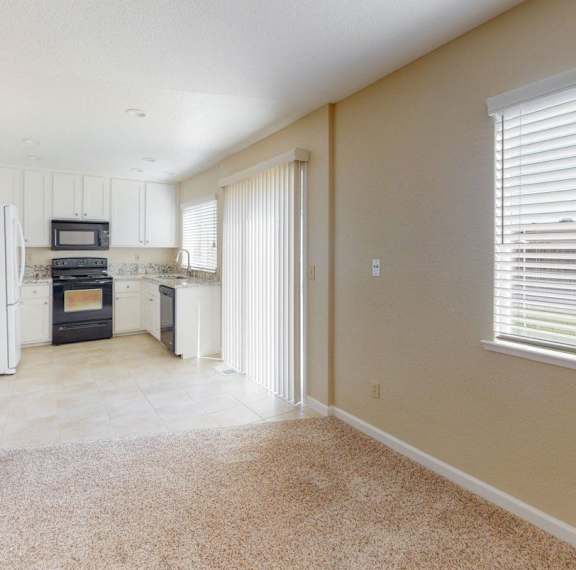 A kitchen with a black stove top oven and white appliances.