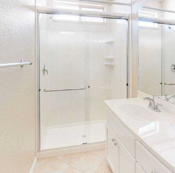 A white bathroom with a walk in shower.