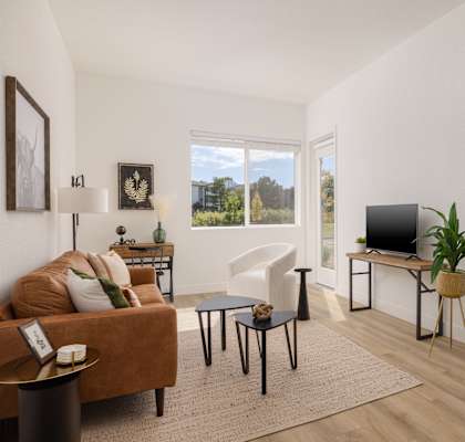 a living room with a couch and a tv and a bedroom with a bed