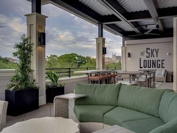 a patio with a green couch and a view of the sky lounge