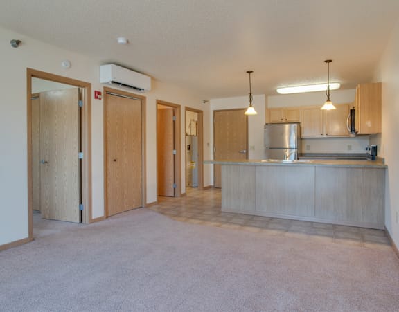 an empty room with white walls and grey carpet