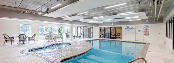 A large indoor swimming pool with a glass wall on one side.