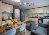 Thumbnail 6 of 8 - a living room and kitchen with a dining table and chairs