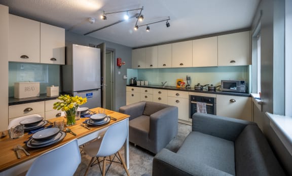 a living room and kitchen with a dining table and chairs