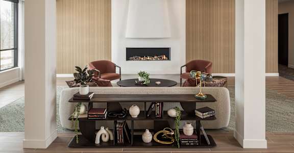 A living room with a fireplace and two chairs.