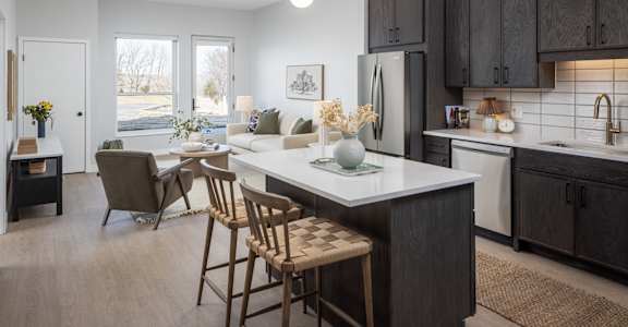 A kitchen with a white countertop and black cabinets.