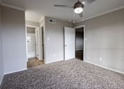 Thumbnail 2 of 5 - A room with a ceiling fan and carpeted floor.