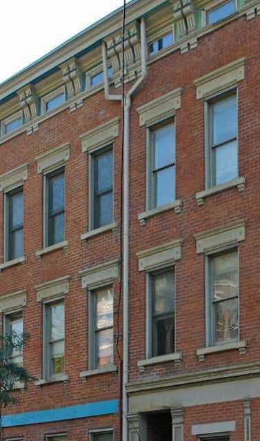 a building on the corner of a street with cars parked in front of it