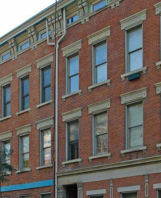 a building on the corner of a street with cars parked in front of it