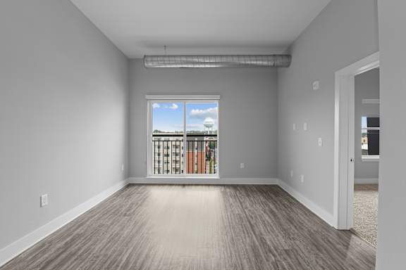A room with a window overlooking a balcony.